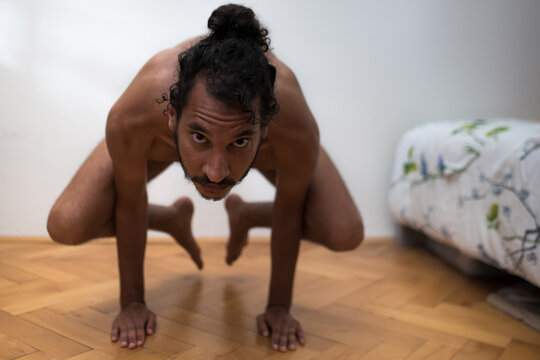 A young Afro European male Yogi does meditation and Hatha Yoga workout at home during lockdown.