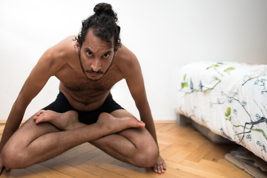 A young Afro European male Yogi does meditation and Hatha Yoga workout at home during lockdown.