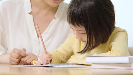 女の子に勉強を教える女性