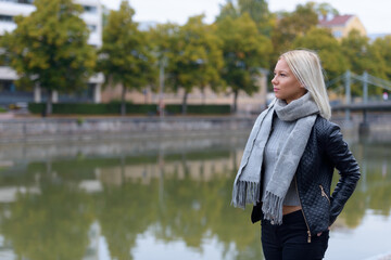 Young beautiful blonde woman thinking in the park along the river