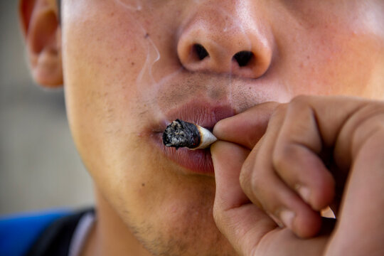 Young man smoking a marijuana cigar