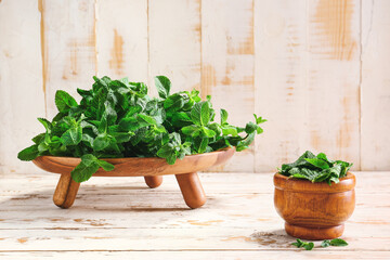Fresh green mint on light wooden background