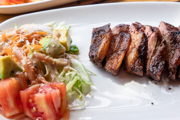 perfectly grilled beef steak with salad in white plate closeup