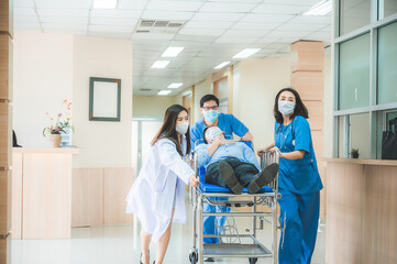 Emergency department, doctors and surgeons team move seriously injured patient lying on a stretcher...