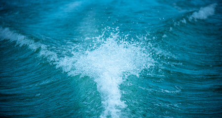 Background of water splash wave surface behind of fast moving motor speed boat