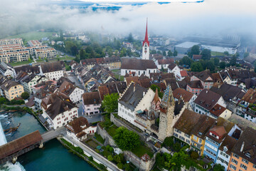 Aerial view of a mid-age city by the river in the fog