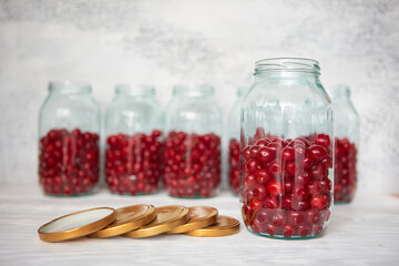 Not closed glass jars with cherries, prepared for canning with tin screw lids