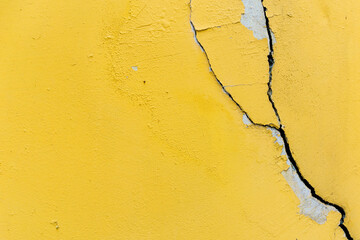 Yellow wall with cracks. Cracked wall.