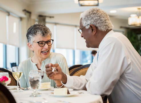 happy senior couple eating meal in restaurant