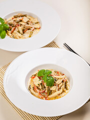 Chicken with vegetables in sesame sauce in a white plate on a plain background. Traditional Thai food. Vertical shot