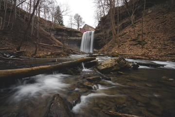 Scenic Landscape Image of a Waterfall in a forest with a mill during autumn