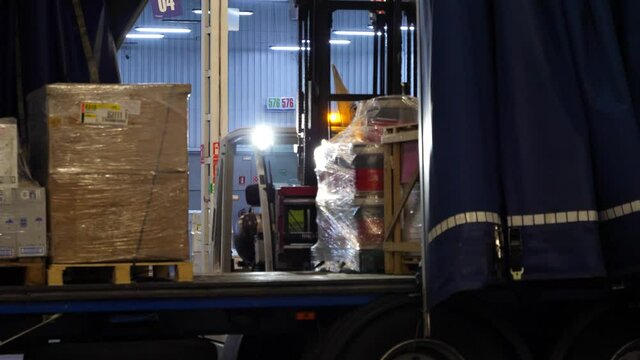 different actions of the loading process of a truck with pallets and pallet trucks