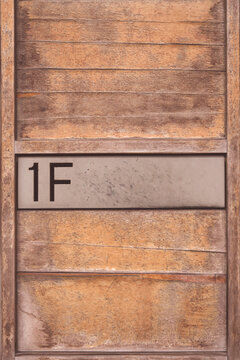 Wooden mailbox with "1F" sign on it. Toned image.