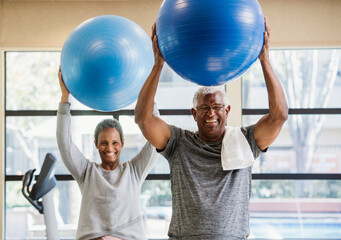 happy senior couple exercising in gym