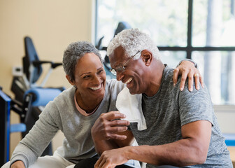 happy senior couple exercising in gym