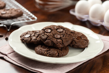chocolate cocoa cookies with chocolate chips. background with tray and recipe ingredients