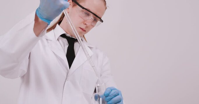 Scientist working in laboratory, processing of the laboratory sample in an Erlenmeyer flask, titration with reagent from a burette.