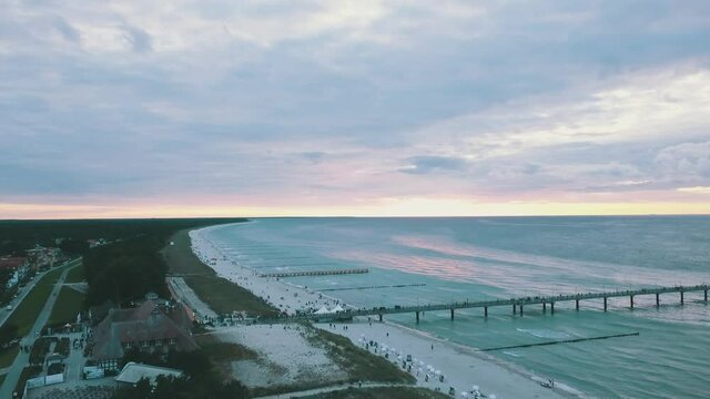 Drone flight during sunset on the beach with light waves of the Baltic Sea.