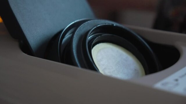 Close shot of a coffee capsule being put on a coffee machine