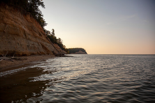 Landscape image of  the famous Calvert Cliffs, taken from the Calvert Cliffs State Park. Image features the steep cliffs with forest on top.