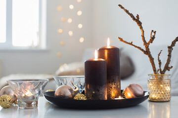 black burning candles with Christmas balls in white interior