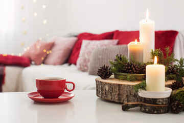 cup of tea with burning candles on white table