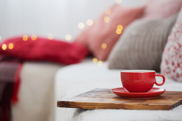cup of tea on wooden tray on sofa