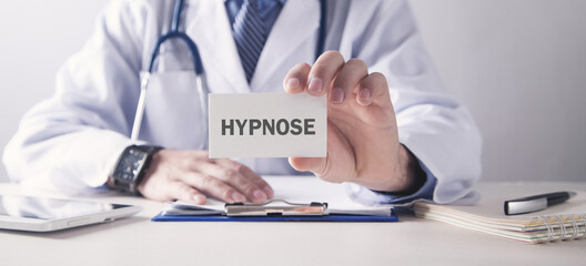 Doctor showing Hypnose word on business card.