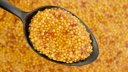 French dijon mustard in black spoon and background