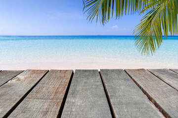 Wooden floor or plank on sand beach in summer. For product display.Calm Sea and Blue Sky Background.