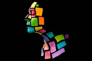 Portrait of a young woman with bold glowing makeup posing in the studio. Shape of colored squares...
