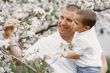 Family in a summer park. Father in a white shirt. Cute little son.