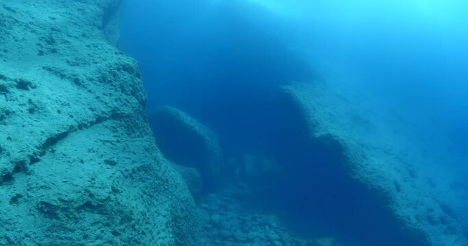 scuba divers exploring the reefs  underwater with rocks ocean scenery enjoying topography mediterranean sea