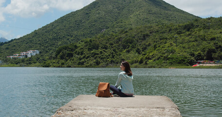 Woman with backpack looks around the mountain and sea view © leungchopan