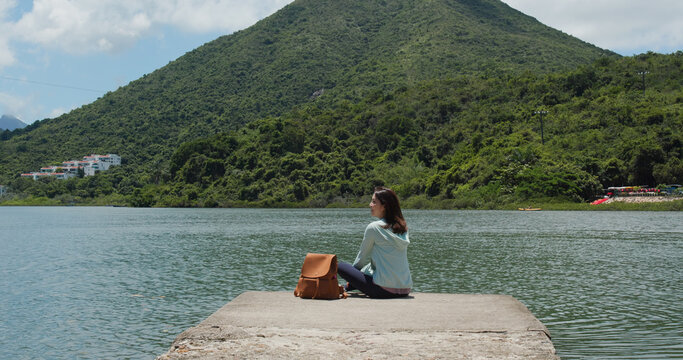 Woman with backpack looks around the mountain and sea view