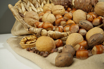 nuts in a basket. beautiful still life close-up on a dark background. Walnut, hazelnuts (hazel), pine nuts, pecans, pine cones.