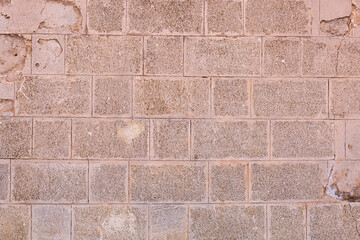 stone wall made of rectangular cobblestones background light brown solid weathered