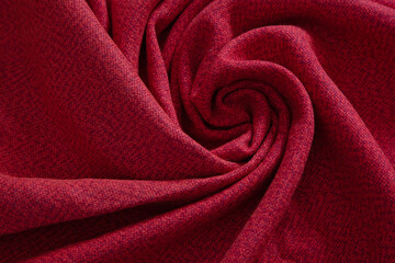 Fototapeta na wymiar Beautiful draped wool fabric. Twisted red fabric for decoration with decorative spiral folds.