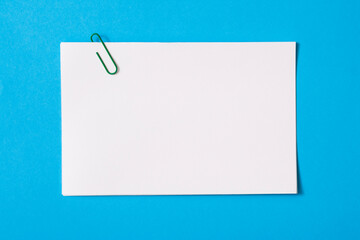 white sheet of paper for notes and paper clip
 - obrazy, fototapety, plakaty