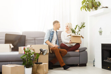 Young couple carrying big cardboard box at new home.Moving house.