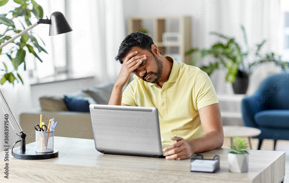 Sticker technology, remote job and business concept - disappointed indian man with laptop computer working at home office