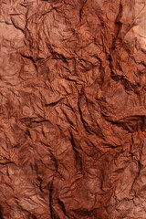 Background of raw crumpled paper. Brown recucled paper with big folds.