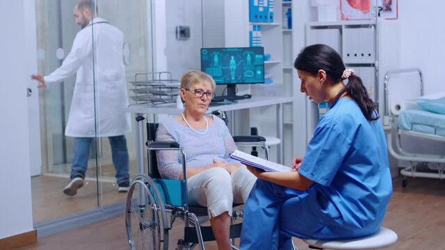 Elderly patient with walking disabilities in wheelchair seeking medical advice in recovery clinic or hospital. Senior handicapped woman health care support medical insurance paralyzed person