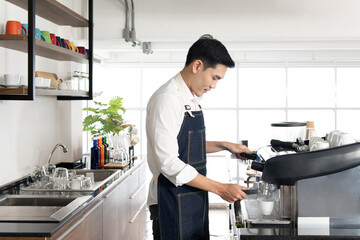 Asian barista man standing to make hot coffee in a cafe shop, working  in the happiness beverage workplace