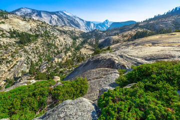 Fototapeta na wymiar Panorama of Olmsted Point, off Tioga Pass Road in Yosemite National Park, California, United States. Clouds Rest is on the left, Half Dome is on the right and Tenaya Canyon between them.