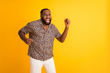 Photo of crazy funny dark skin guy good mood raise fists celebrating success lottery rich person wear golden necklace trend leopard shirt white shorts isolated bright yellow background