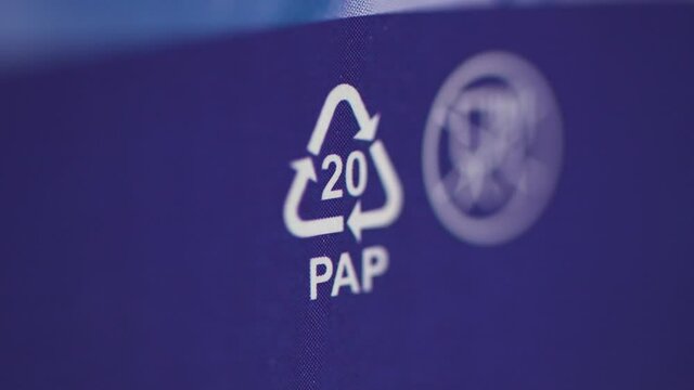 Closeup view of pap sign and other eco-label on blue packaging background spbd. Symbol indicates paper and cardboard. Boxes from household appliances, products, bags. Can be recycled. Concept: ecology