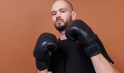 An image of a bearded boxer wearing black pairing gloves.