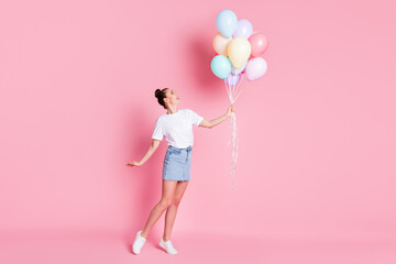 Full length photo of attractive pretty lady pretty bun summer vacation good mood hold many air balloons celebration wear white t-shirt mini skirt shoes isolated pink color background