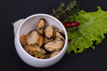 Pickled mussels in the bowl served pepper, garlic and salad